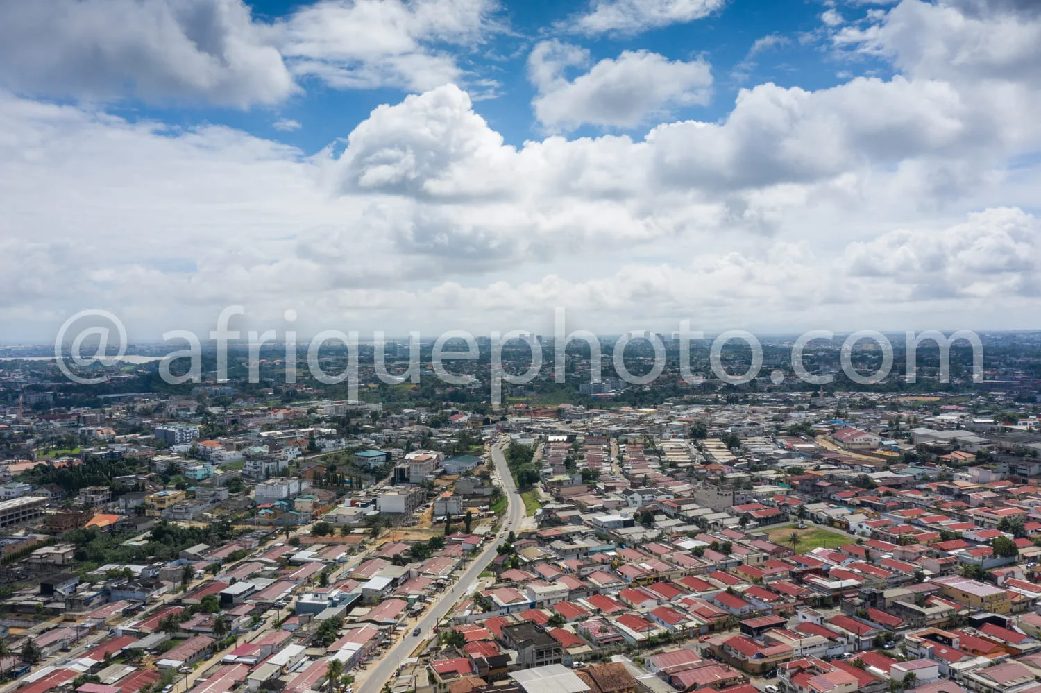Africa photo — Une vue aérienne d'une ville étendue avec des maisons aux toits majoritairement rouges, des rues bien tracées et quelques zones boisées