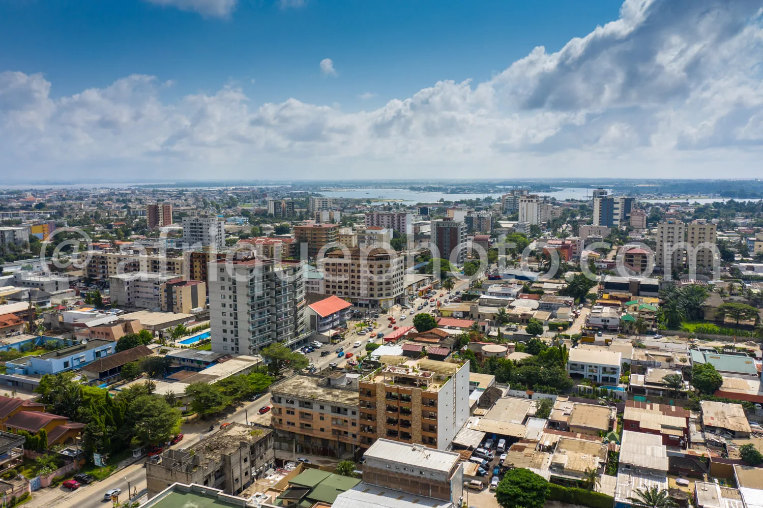 Africa photo — Image montrant une ville dense avec des bâtiments variés, des immeubles récents en construction, des maisons plus anciennes, des rues o