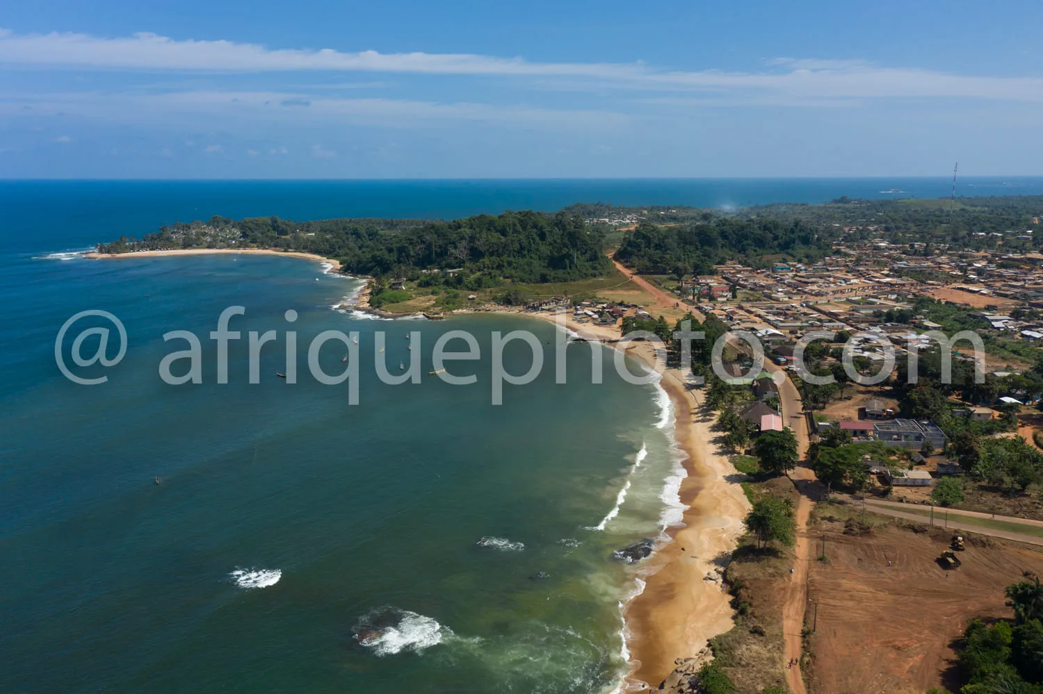 Africa photo — Image aérienne montrant une longue plage de sable bordée d'eaux peu profondes aux teintes turquoise et bleues, entourée de végétation d