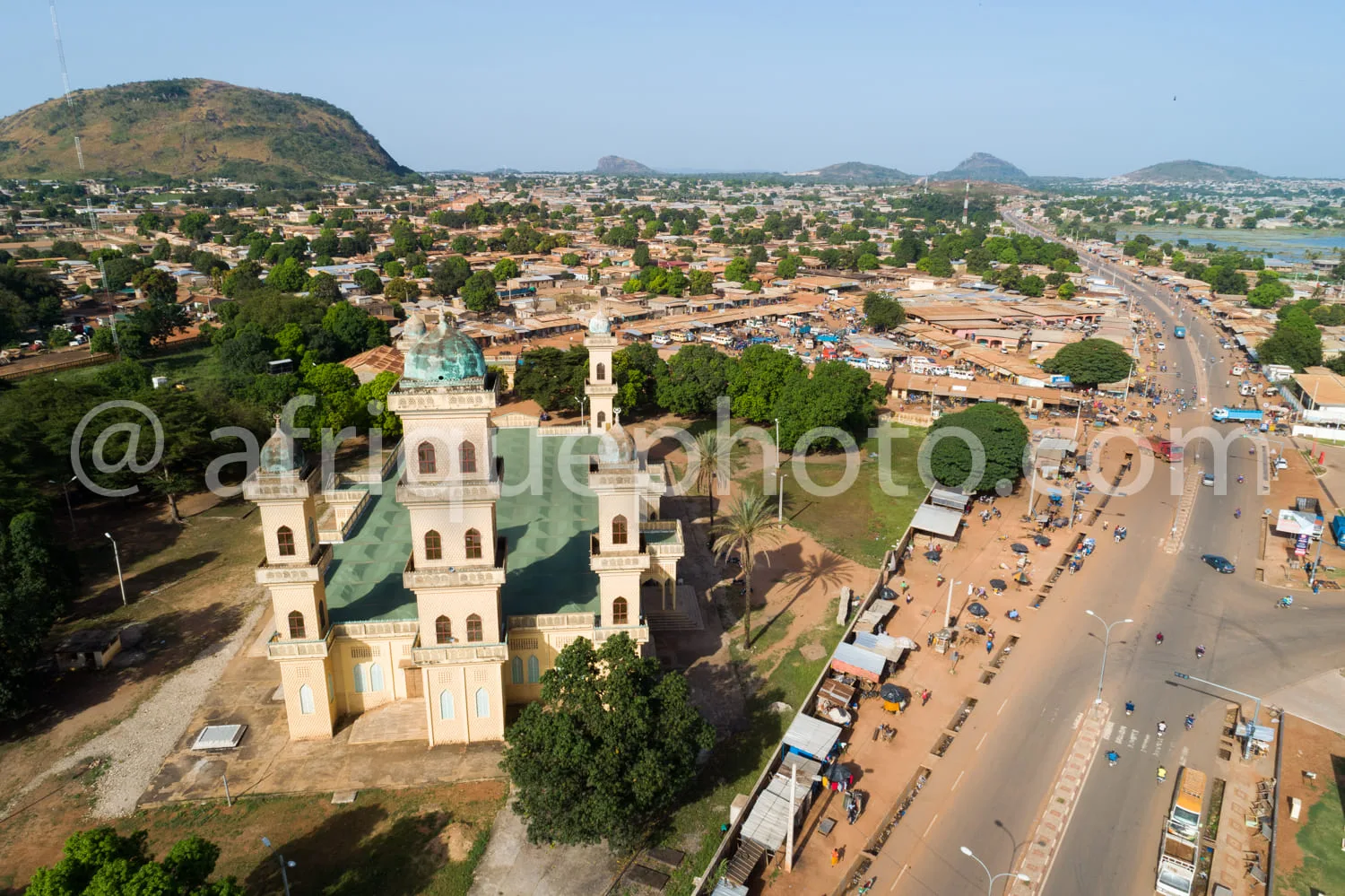 Africa photo — Image montrant une cathédrale coloniale de style architectural européen avec deux tours et un dôme vert, située près d’un marché très f