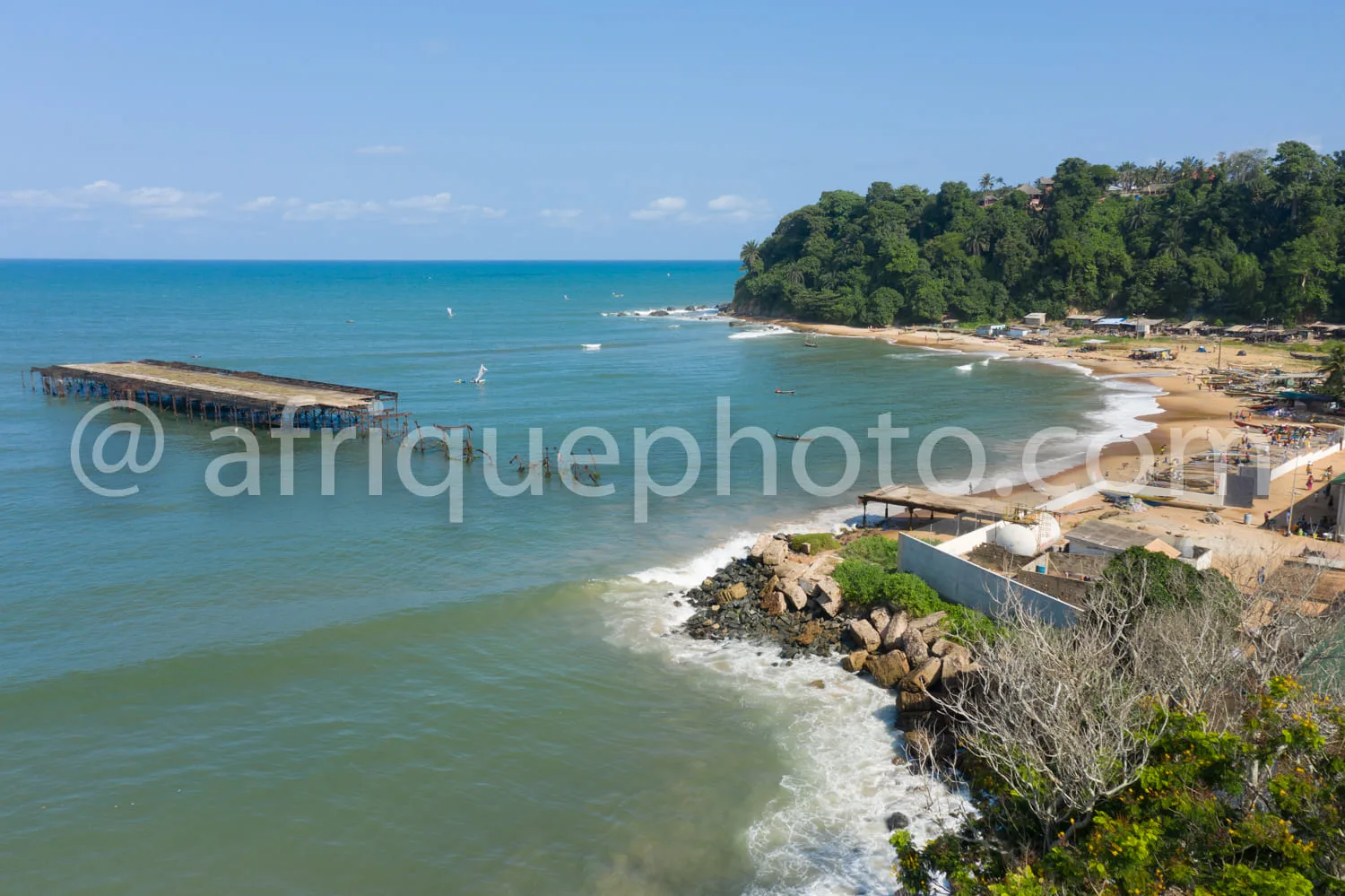 Africa photo — Vue aérienne d'une plage aux eaux turquoise bordée d'une jetée en bois s'étendant dans la mer, avec des vagues douces, un sable clair e