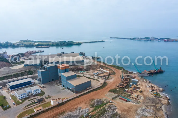 Africa photo — Image aérienne montrant une usine industrielle en bord de mer avec des bâtiments de différentes tailles, des zones de stockage, des rou
