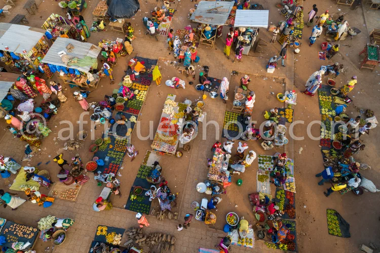 Africa photo — Vue aérienne d’un marché traditionnel très animé où des dizaines de personnes sont assises ou debout autour d’étals remplis de fruits,