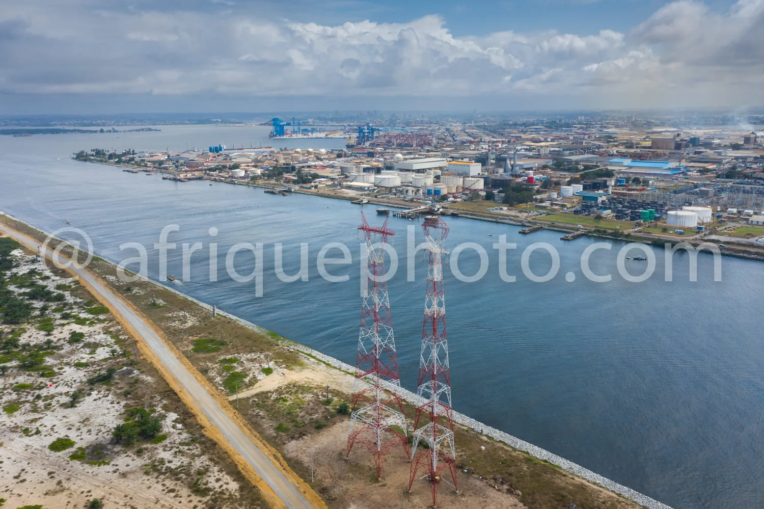 Africa photo — Image aérienne montrant un port industriel situé en bord de mer avec des entrepôts, des grues et des navires. À l'avant-plan, une ligne