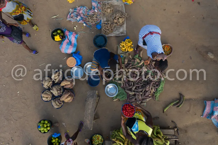 Africa photo — Vue aérienne d’un marché traditionnel où des vendeurs assises sur le sol exposent des paniers remplis de fruits frais comme des bananes