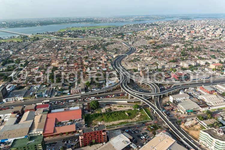 Africa photo — Image montrant une ville dense avec un grand échangeur routier en forme de trèfle, des bâtiments variés, des axes routiers très fréquen