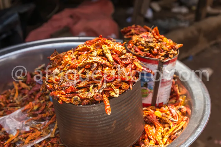 Africa photo — Deux grands pots en métal remplis de crevettes séchées et parfumées aux épices, posés sur un plateau avec d'autres sachets similaires a
