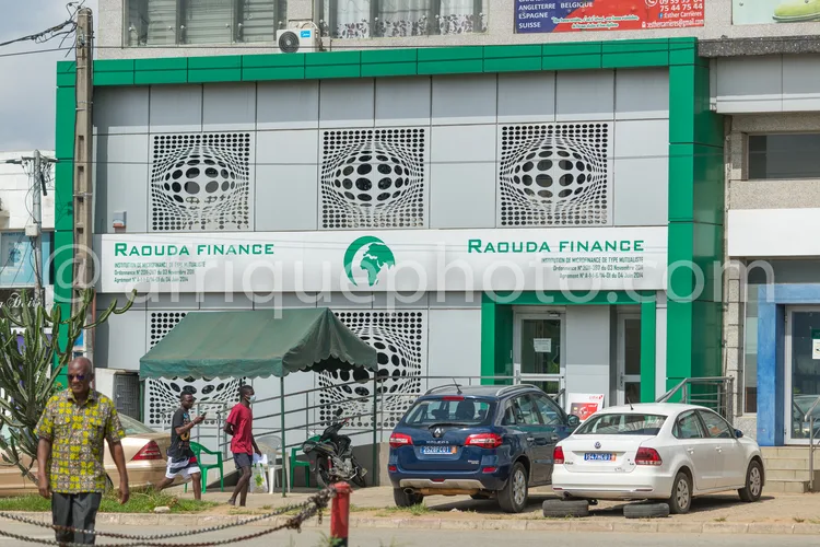 Africa photo — Bâtiment d'une agence Raduda Finance, façade principale avec deux enseignes vertes et logo central, trois fenêtres en relief décoratif,