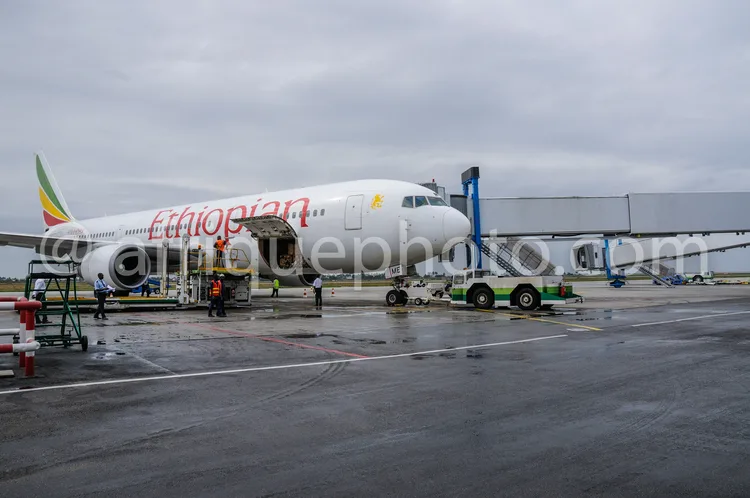 Africa photo — Un avion de la compagnie Ethiopian Airlines, reconnaissable à son livrée blanche et ses lettres rouges, est stationné sur une piste mou