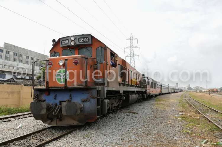 Africa photo — Une locomotive orange et bleue, portant le numéro 22105, circule sur une voie ferrée avec plusieurs wagons derrière elle. On aperçoit d