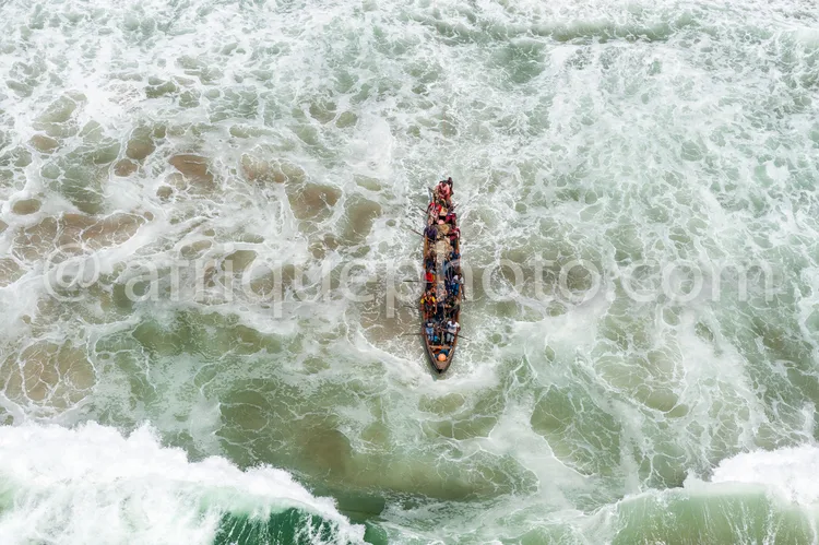 Africa photo — Un bateau de pêche chargé, probablement de filets ou de marchandises, navigue en pleine mer agitée avec des vagues blanches et écumante