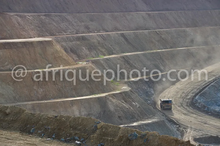 Africa photo — Vue aérienne d'une immense carrière à ciel ouvert où un camion de transport circule sur une piste sinueuse entre des parois de terre ex