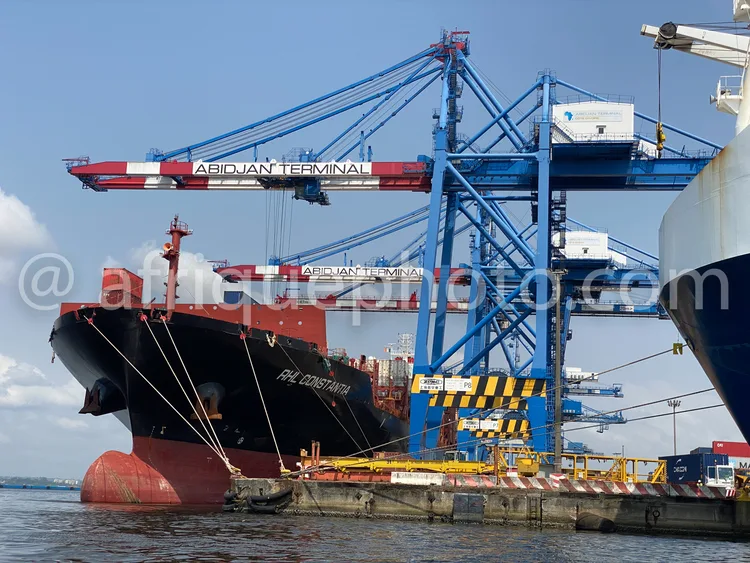 Africa photo — Image d'un cargo nommé M/V Al Konstantia accosté au terminal portuaire d'Abidjan. Deux grues bleues et rouges, marquées Abidjan Termina