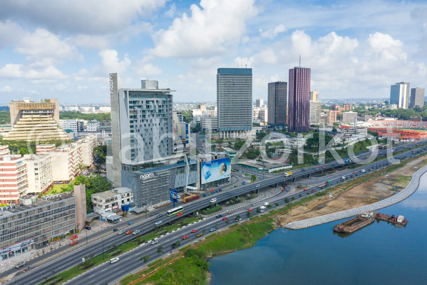 Africa photo — Vue aérienne d’une ville moderne avec des immeubles de bureaux et des gratte-ciels, une large autoroute très fréquentée bordée de véhic