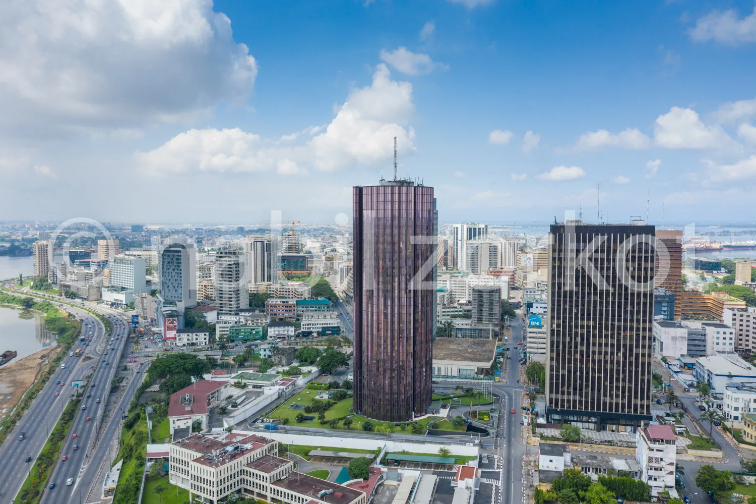 Africa photo — Vue aérienne d’une ville moderne avec deux gratte-ciels imposants au centre, entourés de bâtiments variés, de routes bien tracées et d’
