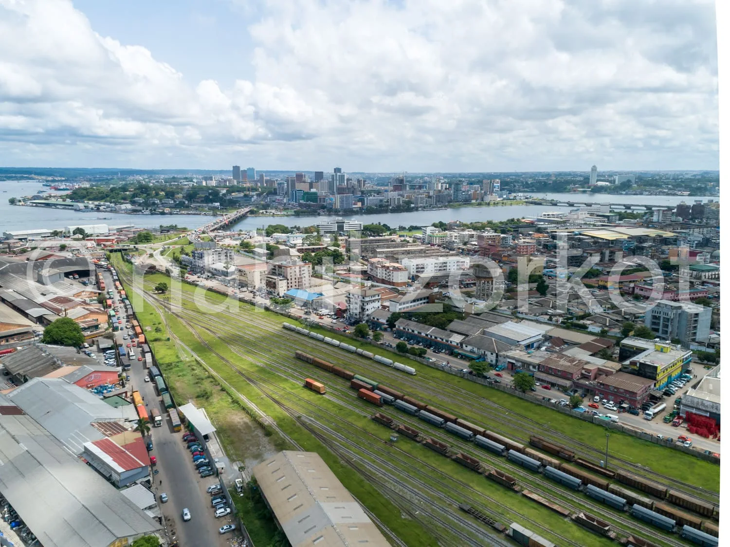 Africa photo — Image aérienne montrant une ville avec une voie ferrée centrale bordée de voies de chemin de fer, des bâtiments résidentiels et commerc