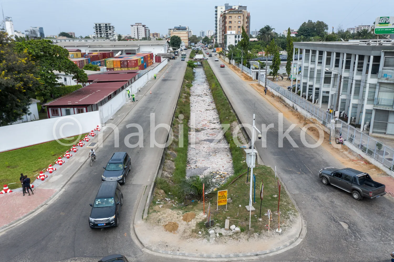 Africa photo — Image aérienne d'une voie urbaine en cours d'aménagement où une canalisation centrale est ouverte, avec des véhicules circulant sur la