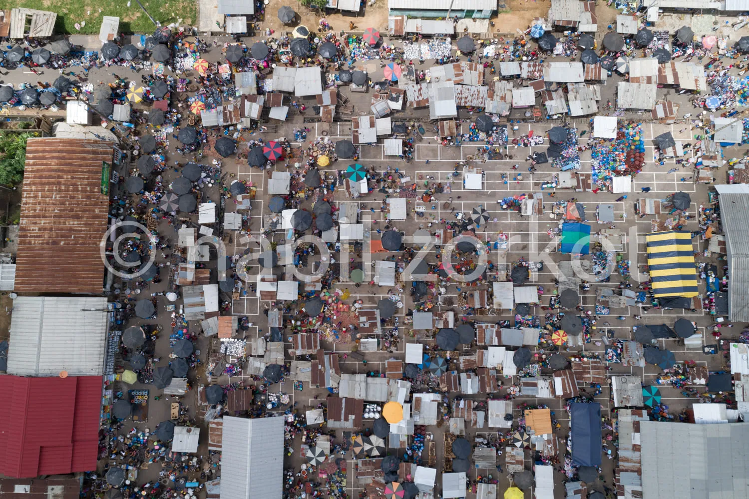 Africa photo — Vue aérienne d'un vaste marché de plein air où des centaines de tentes et étals, principalement blancs et noirs, sont alignés de manièr
