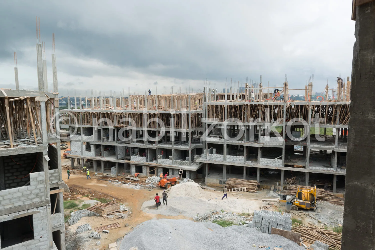 Africa photo — Vue aérienne d’un chantier de construction où l’on distingue un squelette en béton d’un bâtiment résidentiel avec l’inscription 'Zikout