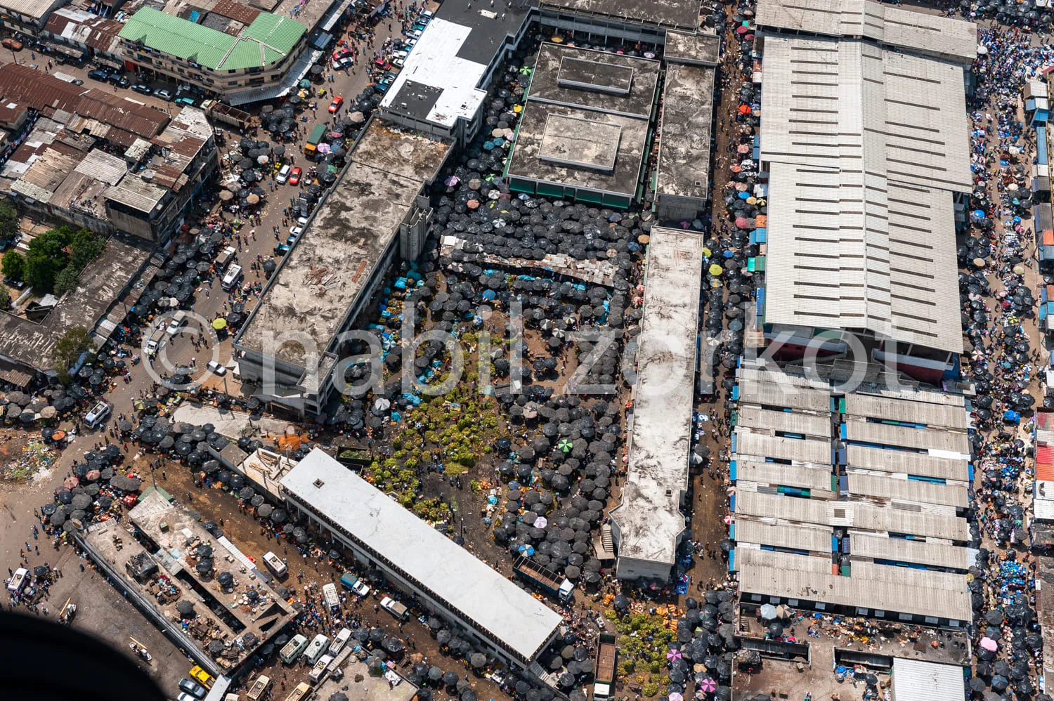 Africa photo — Image aérienne montrant un marché de rue partiellement détruit par un incendie, avec des échafaudages et des toits temporaires en place