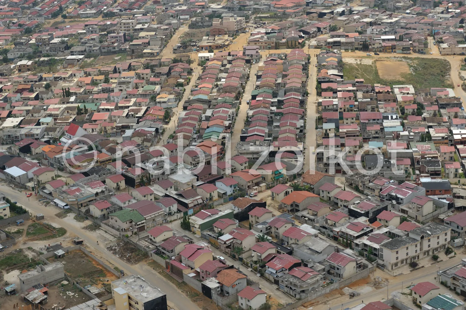Africa photo — Vue aérienne d’un quartier résidentiel composé de nombreuses maisons aux toits colorés, alignées le long de rues larges et bien définie