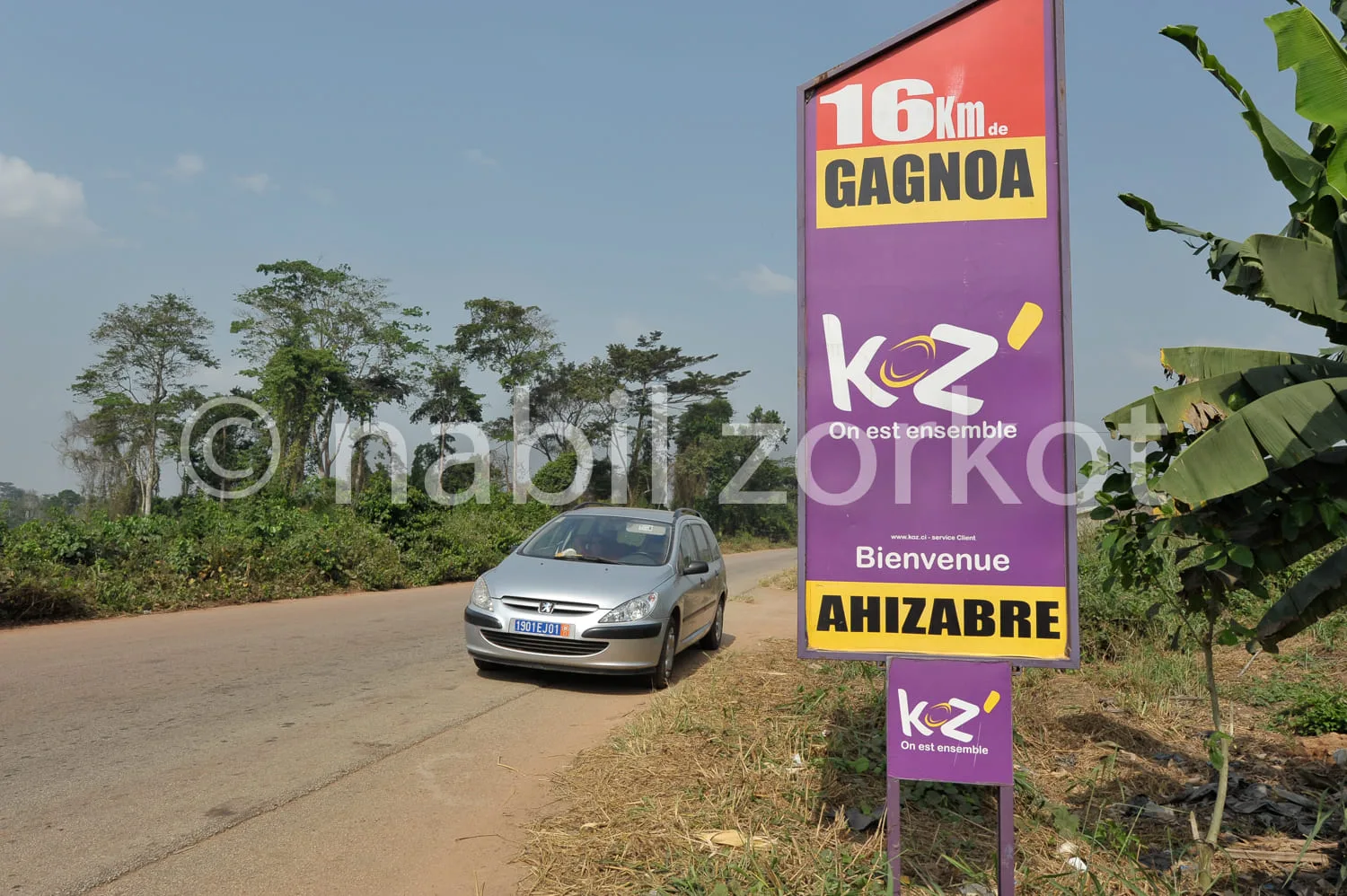 Africa photo — Panneau routier indiquant 16 kilomètres jusqu’à Gagnoa en haut, avec en bas un message de bienvenue pour Ahizabre, accompagné du logo K